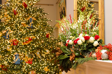 May ilaw na puno at wreath sa mantle