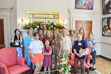 Ang Unang Ginang ay nag-pose kasama ang isang grupo ng mga kababaihan sa Ladies' Parlor sa Executive Mansion sa Historic Garden Day.