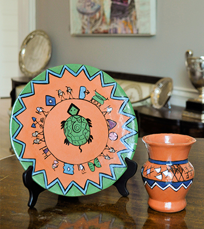 Isang terracotta plate at plorera na may simbolismong Native American.
