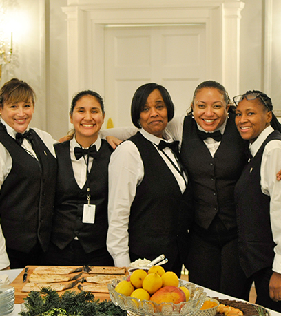 Limang babaeng staff ng Executive Mansion team ang nag-pose sa dining room.