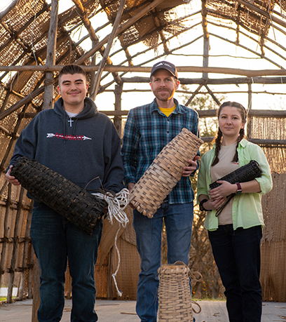 Mula sa kaliwa, sina David Onks, Brad Hatch at Reagan Andersen ay may hawak na mga eel pot sa isang longhouse na ginagawa sa Patawomeck Museum and Cultural Center sa Fredericksburg noong Linggo, Disyembre 11, 2022.